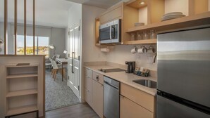 A modern kitchen with a built-in oven, stainless steel refrigerator, and wooden cabinets. - Towneplace Suites By Marriott Great Falls (Great Falls)
