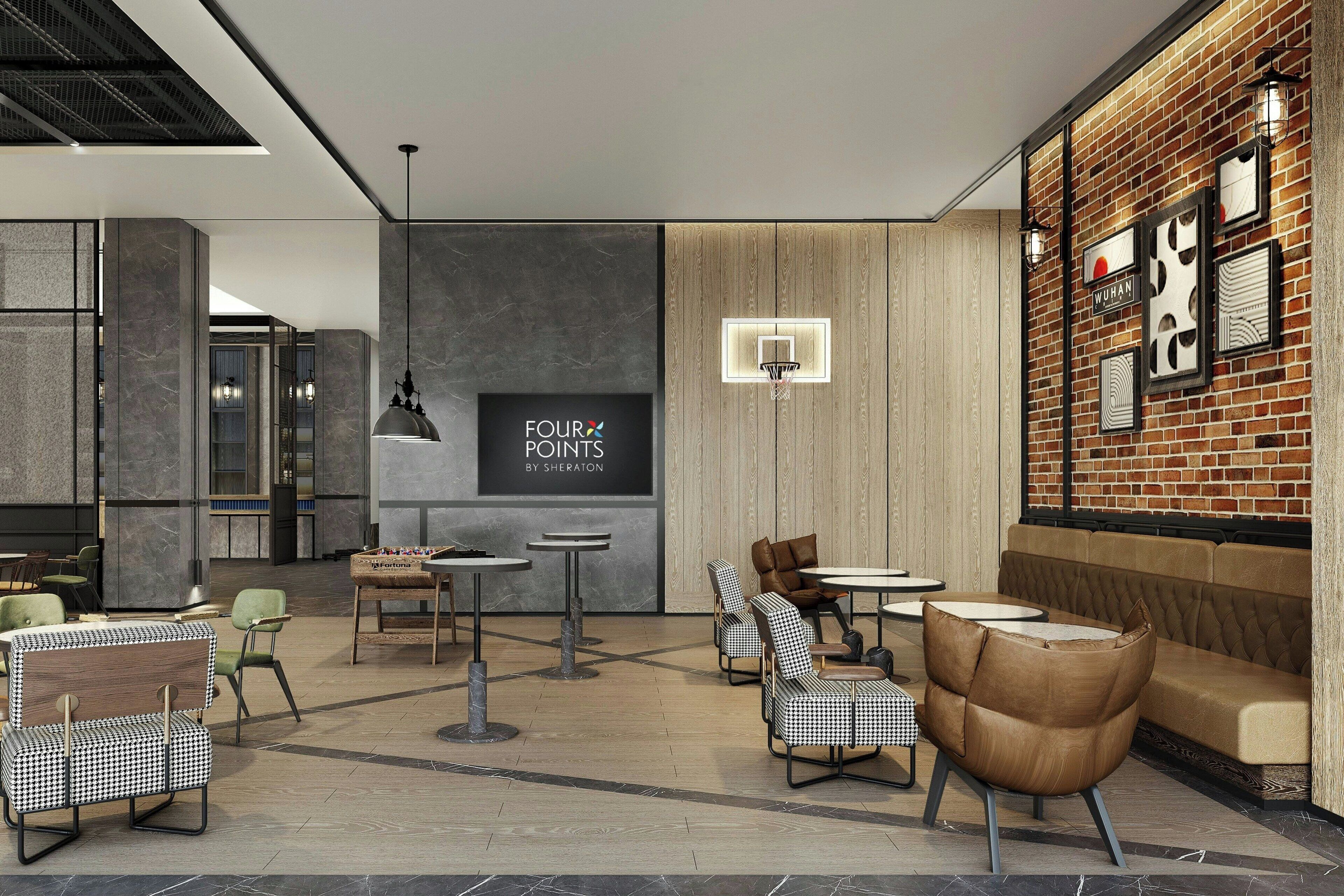 A modern lounge area with seating, a wall-mounted sign, and a brick wall with framed artwork.