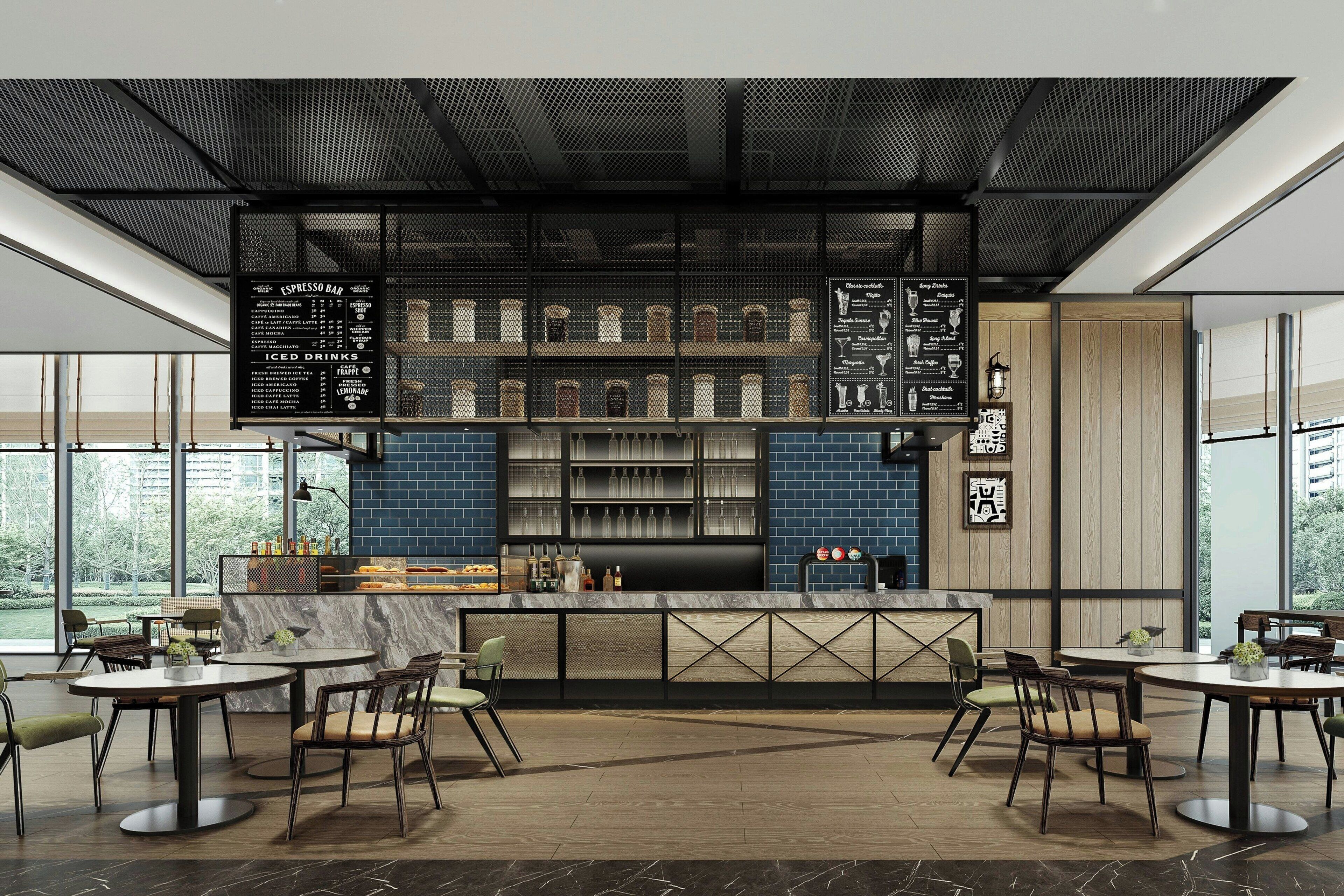 Un espace bar moderne doté d’un tableau affichant le menu, de sièges et offrant une vue sur l’extérieur.
