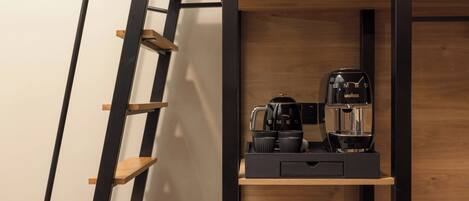 A modern kitchen with a built-in coffee station, wooden shelves, and a ladder.