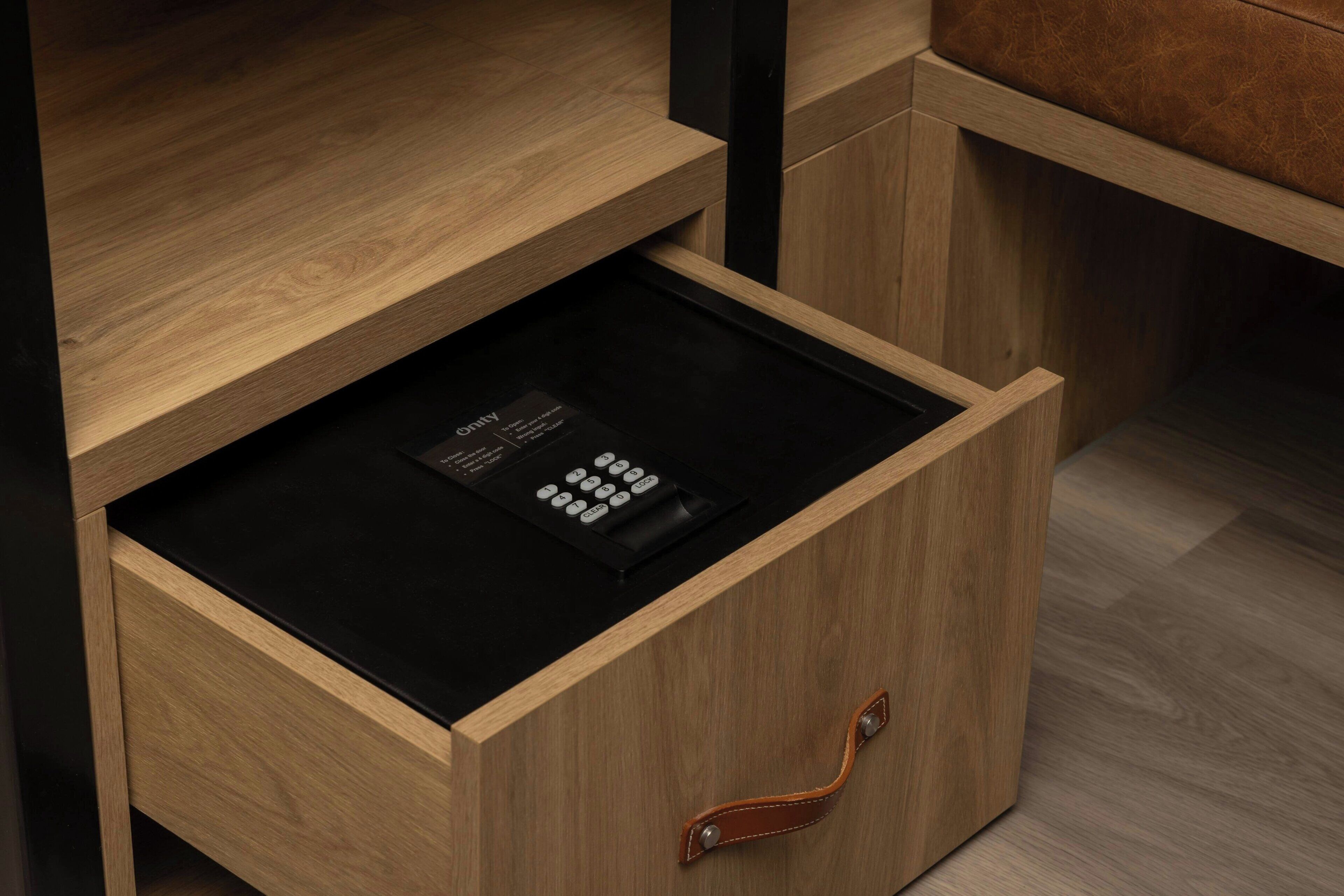 A wooden drawer with a black electronic device inside.
