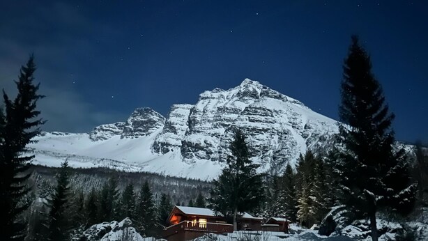 A snow-covered mountain with a wooden cabin in the foreground. - Maxi’s Cabin with Sauna and Jacuzzi (Troms)