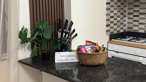 Un comptoir de cuisine avec un panneau, un panier de collations et une plante en pot.