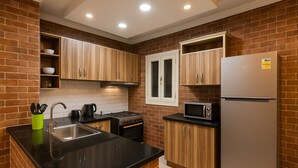 A kitchen with a stainless steel sink, a stove, a microwave, and a refrigerator. - wake up to the pyramids (Giza)
