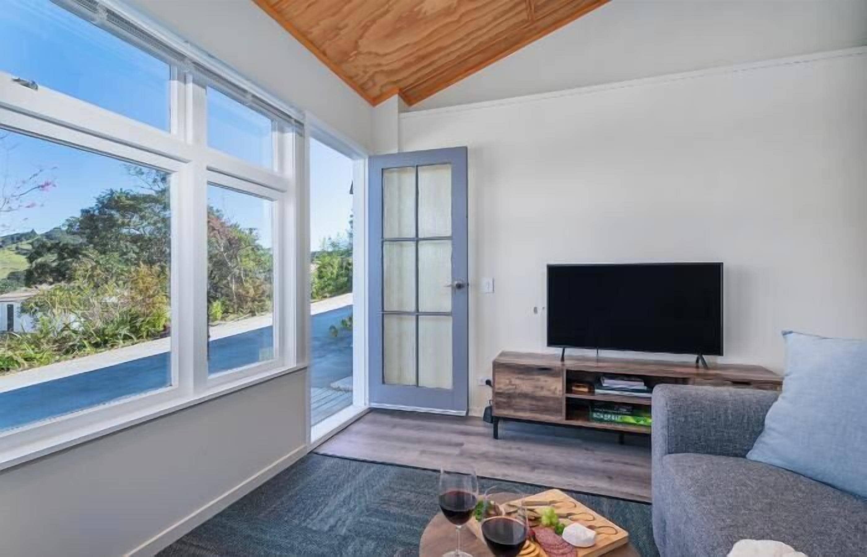 Uma sala de estar moderna com televisão, sofá e mesa de centro.