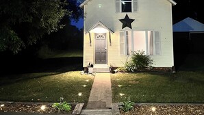 A house with a front porch, a door, and a star decoration on the front. - Lake Superior Stay - Fire Pit Patio - Pet Friendly (Ashland)