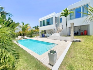 A modern two-story house with a swimming pool, surrounded by well-maintained grass and palm trees. - 3 BR luxury Villa with Pool close to Cabarete (Cabarete)