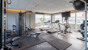 A gym with treadmills, weight machines, and a rowing machine. - Studio Just a few Steps From the Beach - Kpl0806 (Sao Jose)