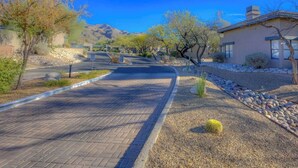 A paved driveway leading to a house with a mountain backdrop. - Ventana Luxe | Design-Driven 2BR Condo Near Sabino & Ventana Canyons with Pools (Tucson)