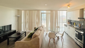 Apartamento luxo, 1 quarto, vista para a cidade | Área de estar | Smart TV 40 polegadas com canais a cabo