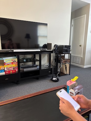 A living room with a TV, a black entertainment unit, and a coffee table. - Cozy, Cute, Superb 2-bedroom house Centrally located in Piedmont (Piedmont)