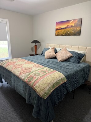 A bedroom with a bed, a nightstand, a lamp, and a painting on the wall. - Cozy, Cute, Superb 2-bedroom house Centrally located in Piedmont (Piedmont)