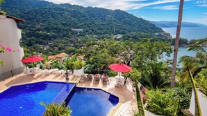 A pool area with a view of a mountainous landscape and a body of water. - Charming 2-bedroom, 2 bath condo in Mismaloya with AC, remodeled kitchen & baths (Mismaloya)