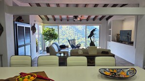 A modern dining area with a table, chairs, and a view of the outdoors. - Charming 2-bedroom, 2 bath condo in Mismaloya with AC, remodeled kitchen & baths (Mismaloya)