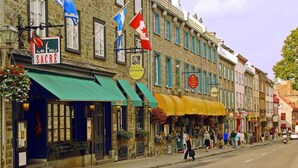 A street with buildings, flags, and outdoor seating areas.