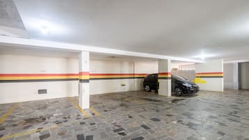 Un estacionamiento con espacios numerados y un coche negro estacionado en uno de ellos.