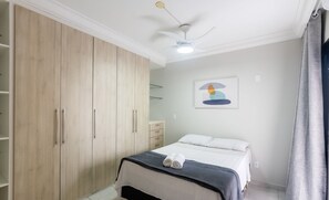 A bedroom with a bed, a wardrobe, a ceiling fan, and a painting on the wall. - 3 Bedroom Apartment 190m From the Beach Epp0602 (Guarapari)
