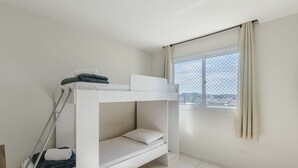 A bunk bed room with a window and curtains, a ladder, and a view of the city. - Apartment With Balcony 500m From the Beach Emz0504 (Guarapari)