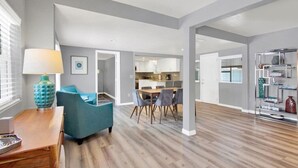 Un espacio habitable amplio con una mesa de comedor, sillas y un sillón azul.
