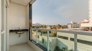 A balcony with a view of a cityscape, a small sink, and a glass railing. - Charming Apt Just 450m From the Beach Emm0202 (Guarapari)
