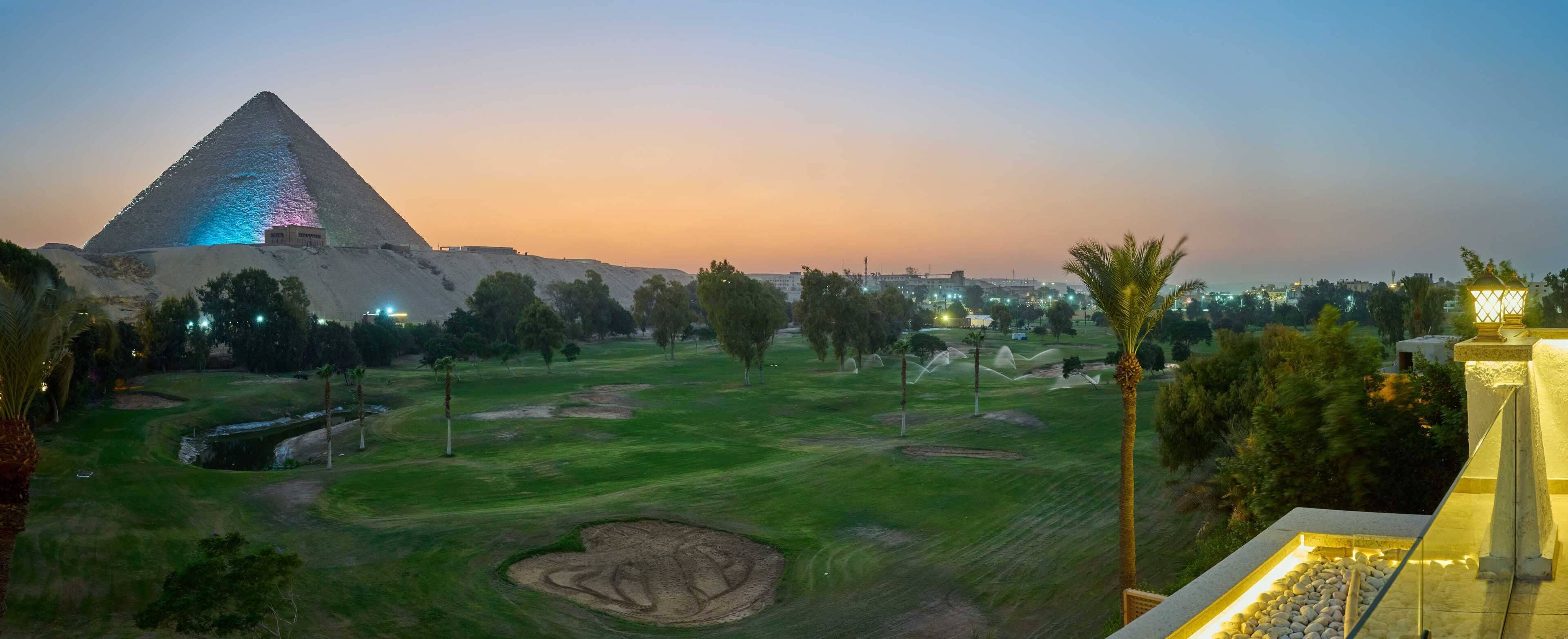 A golf course with a pyramid in the background.