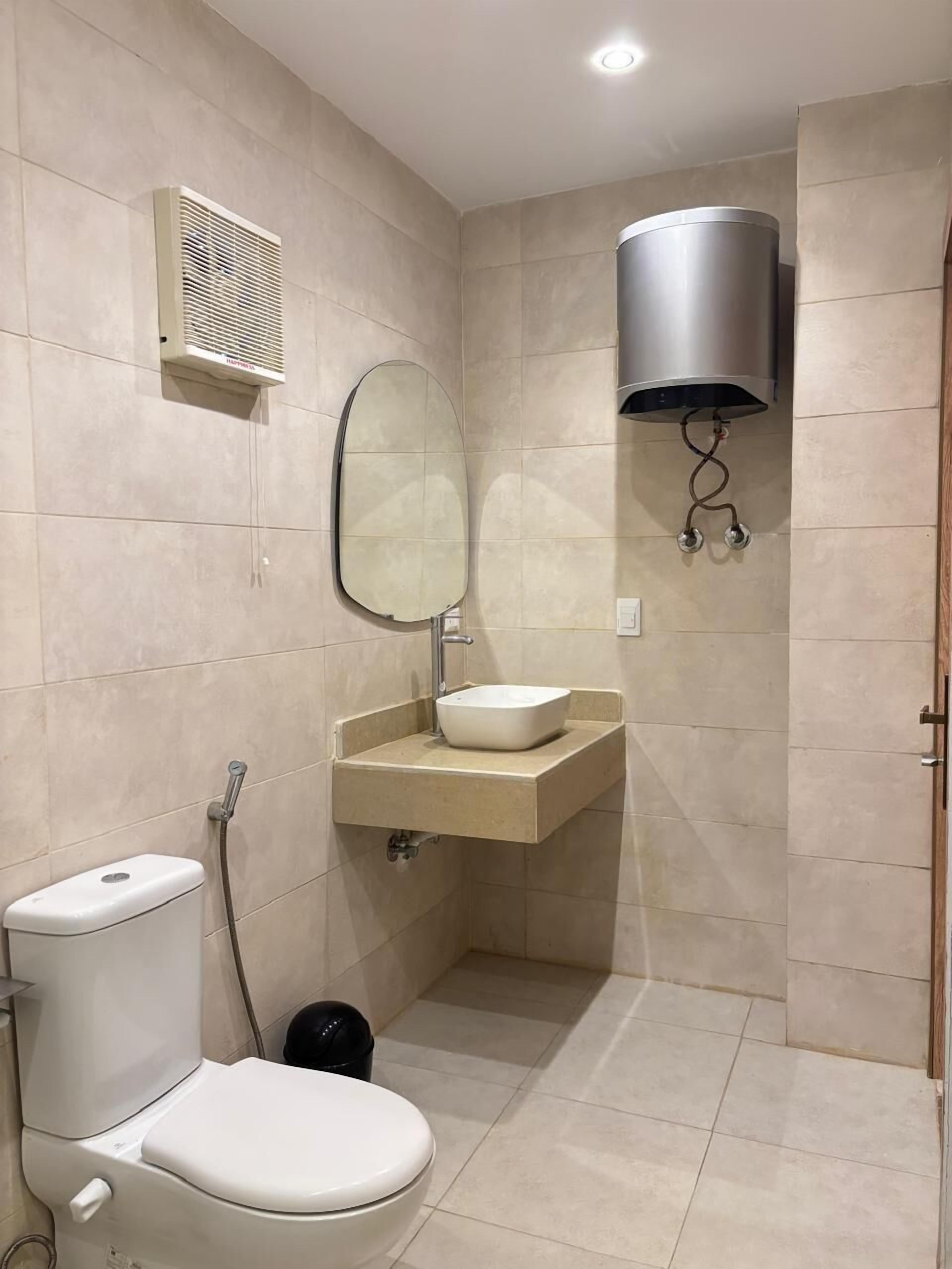 Ein kleines Badezimmer mit Toilette, Waschbecken, Spiegel und Dusche.