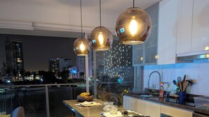 A modern kitchen with a central island, bar stools, stainless steel appliances, and pendant lighting. - Beautiful  loft in Barranco (Barranco)