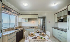 A modern kitchen with a dining area, a view of the sea, and a sign indicating no smoking. - Stay With an Ocean View! Elg0071 (Barra Velha)