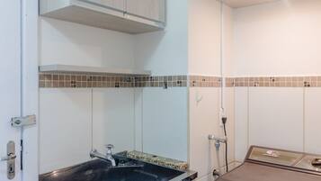 A bathroom with a sink, a toilet, and a shower area.
