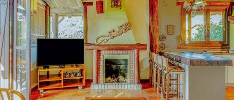 A living room with a fireplace, a television, and a bar area.