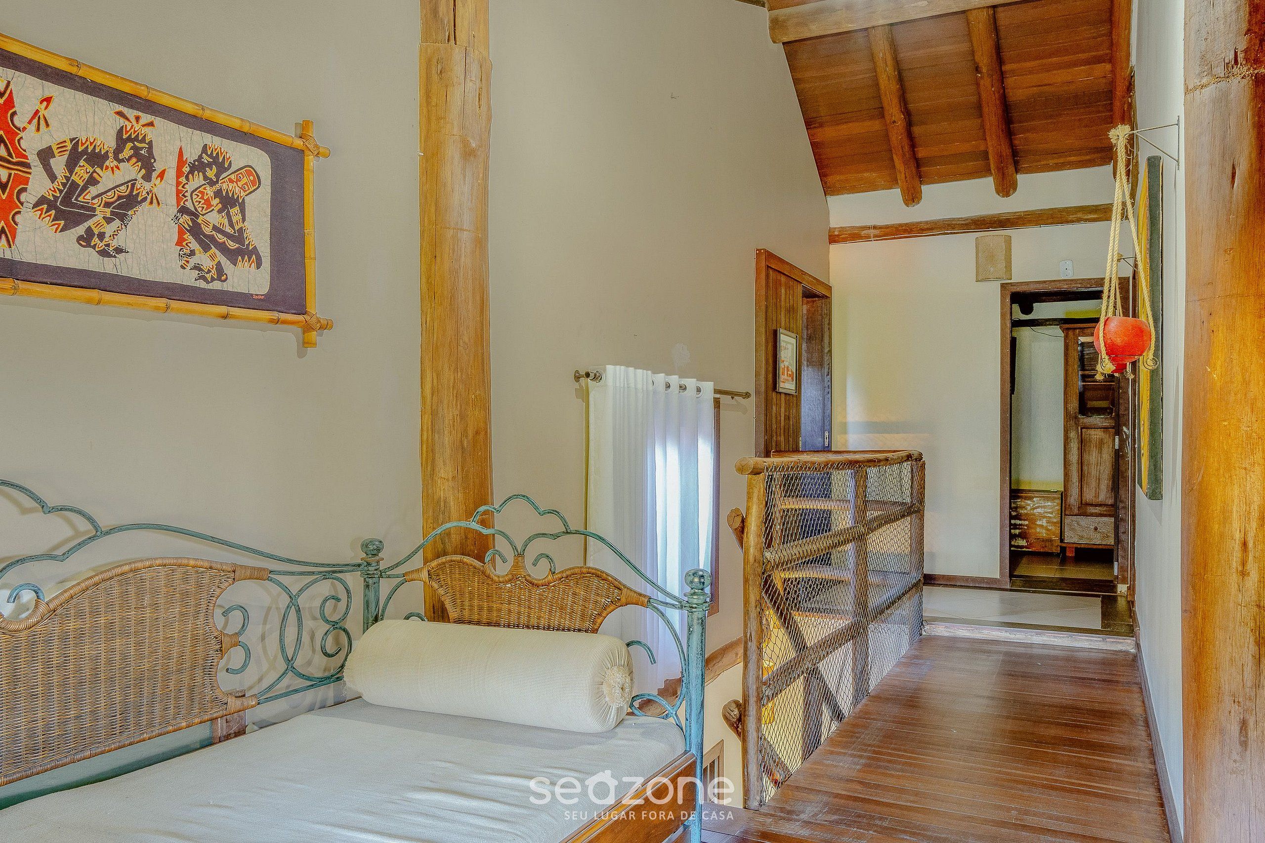 Une chambre avec un lit, un plafond en bois, une tête de lit en osier et une décoration murale.