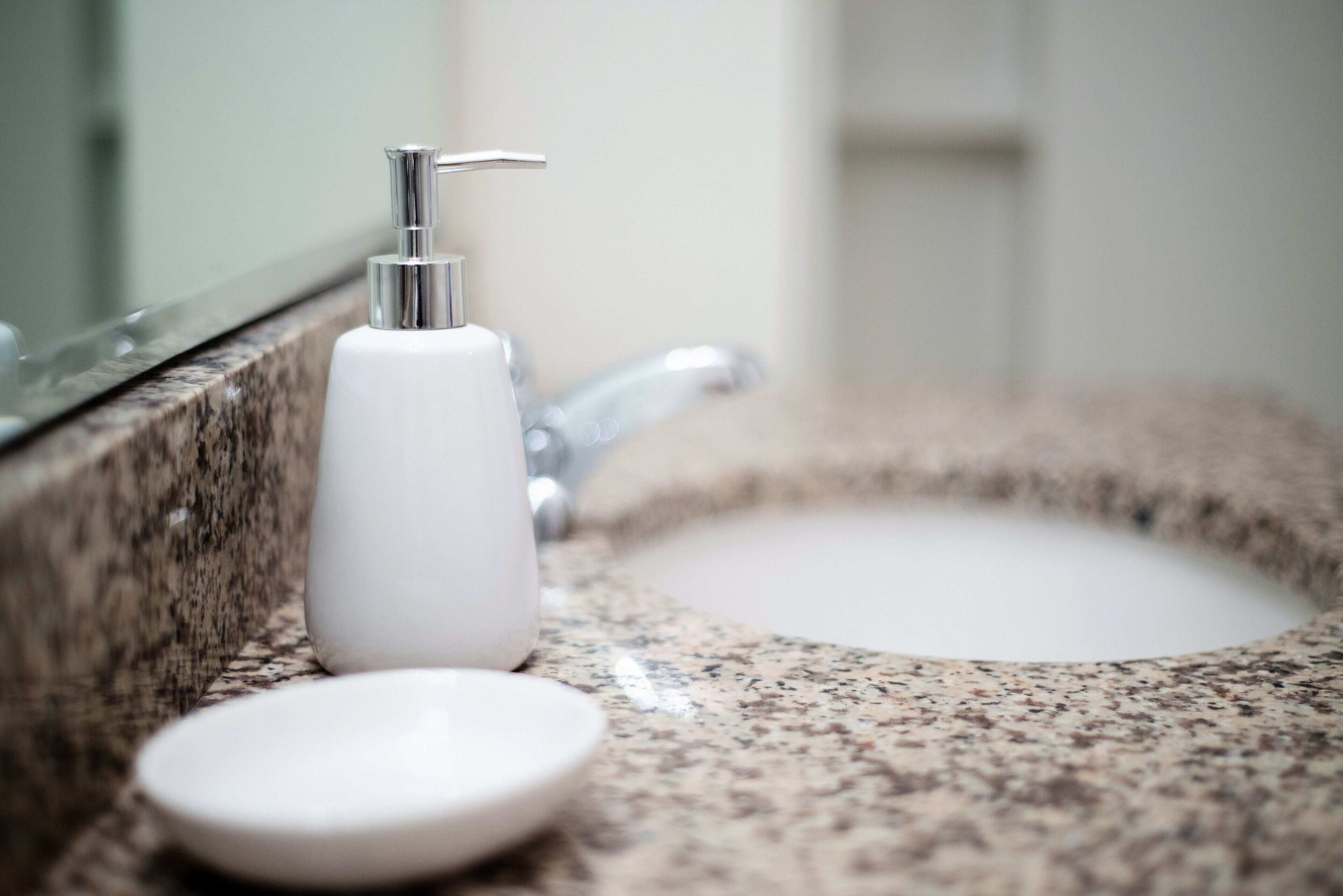A bathroom sink with a marble countertop and a chrome faucet.