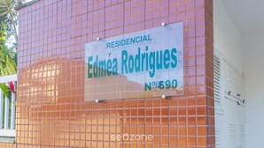 A residential building with a tiled facade and a sign indicating it is 'Edmée Rodrigues No. 690'. - Beautiful Apart With Balcony and Barbecue Ecu102 (Ubatuba)
