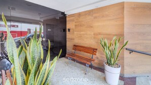 A bench and potted plants in a building's entrance area. - Cozy Apt 350m From Praia do Forte Ecf0306 (Cabo Frio)