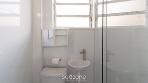 A bathroom with a toilet, sink, and a glass shower enclosure. - Apt w/ Balcony 650m From Beach, Cabo Frio Cvy0306 (Cabo Frio)