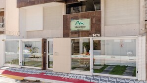 A modern building with a sign for Villa du Monte residential. It features large windows, a visible garage, and a tiled entrance area.