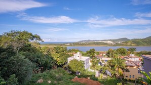 Una zona residencial costera con casas rodeadas de exuberante vegetación y vistas al mar.