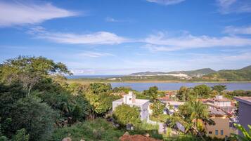 Uma área residencial costeira com casas cercadas por vegetação exuberante e vista para o mar.