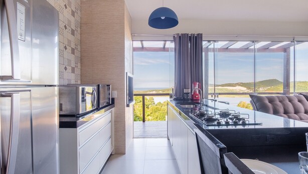 Una cocina moderna con vista al exterior, un comedor con vistas y un ventanal con cortinas.
