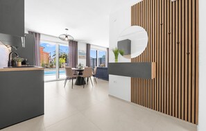 Eine moderne Küche mit Essbereich, großen Fenstern und Blick ins Freie.