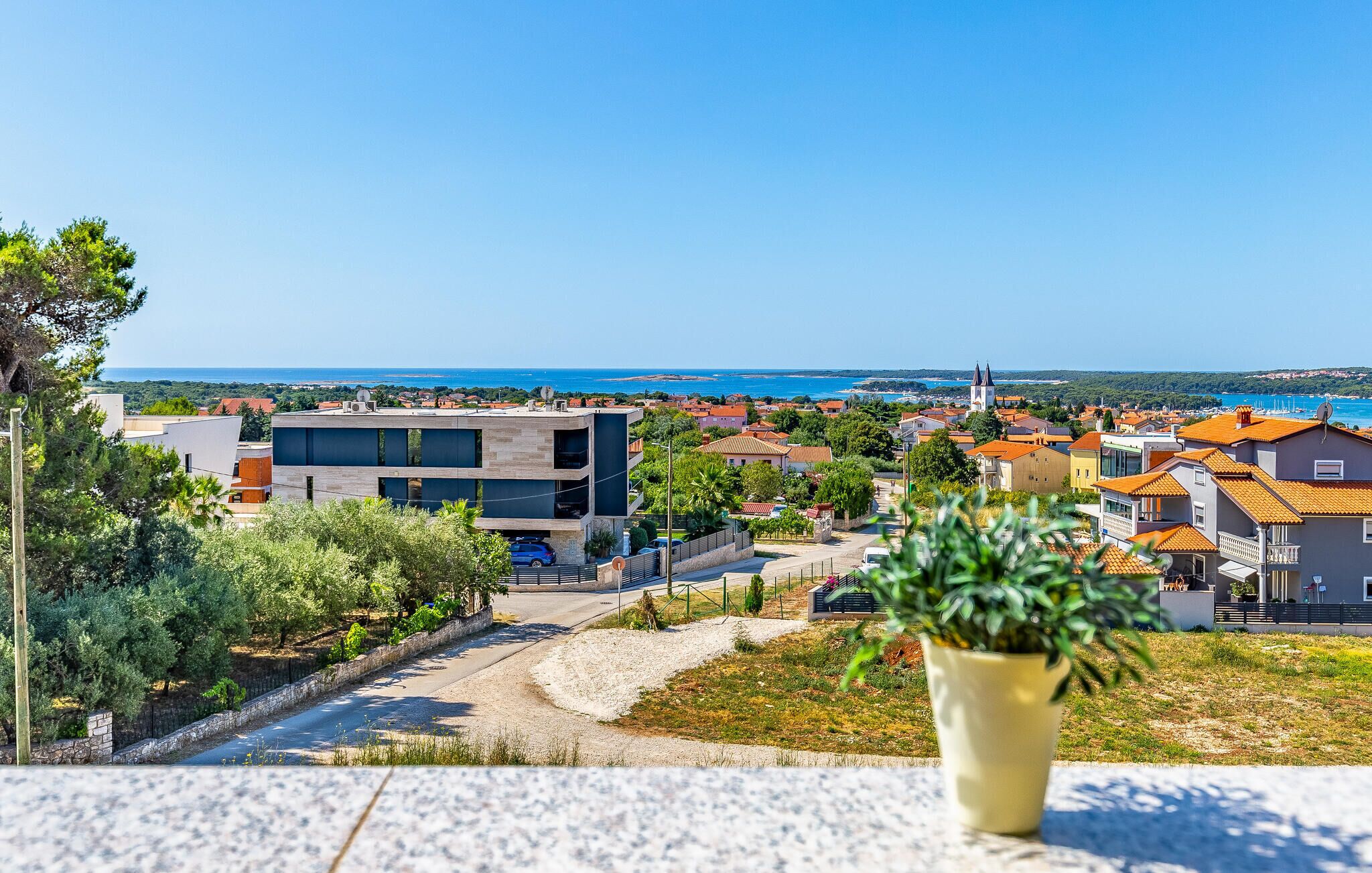 Eine Küstenstadt mit modernen Gebäuden, freiem Blick auf das Meer und einer markanten Kirche.