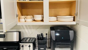 A kitchen with a toaster, a coffee maker, and a knife block. - Charming Elegant Room (Richmond)