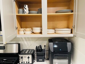 A kitchen with a toaster, a coffee maker, and a knife block.