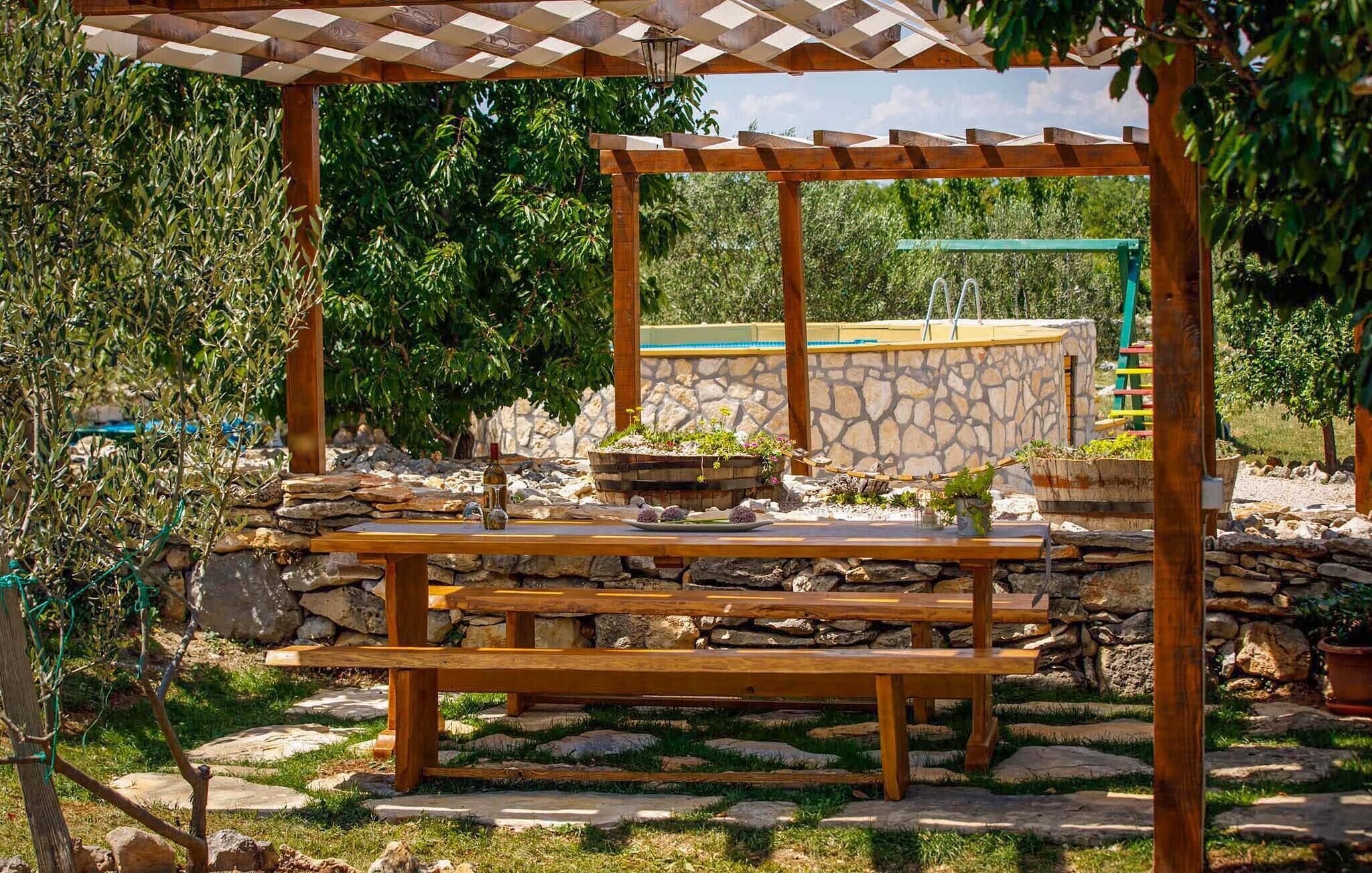 Ein Außenbereich mit Holzbänken und einer Pergola.