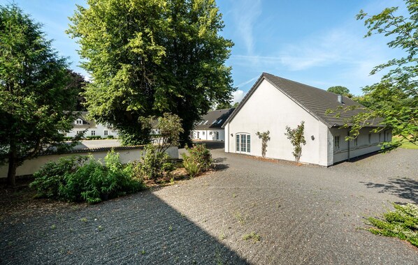 Un bâtiment doté d’un toit en pente et d’une allée gravillonnée.