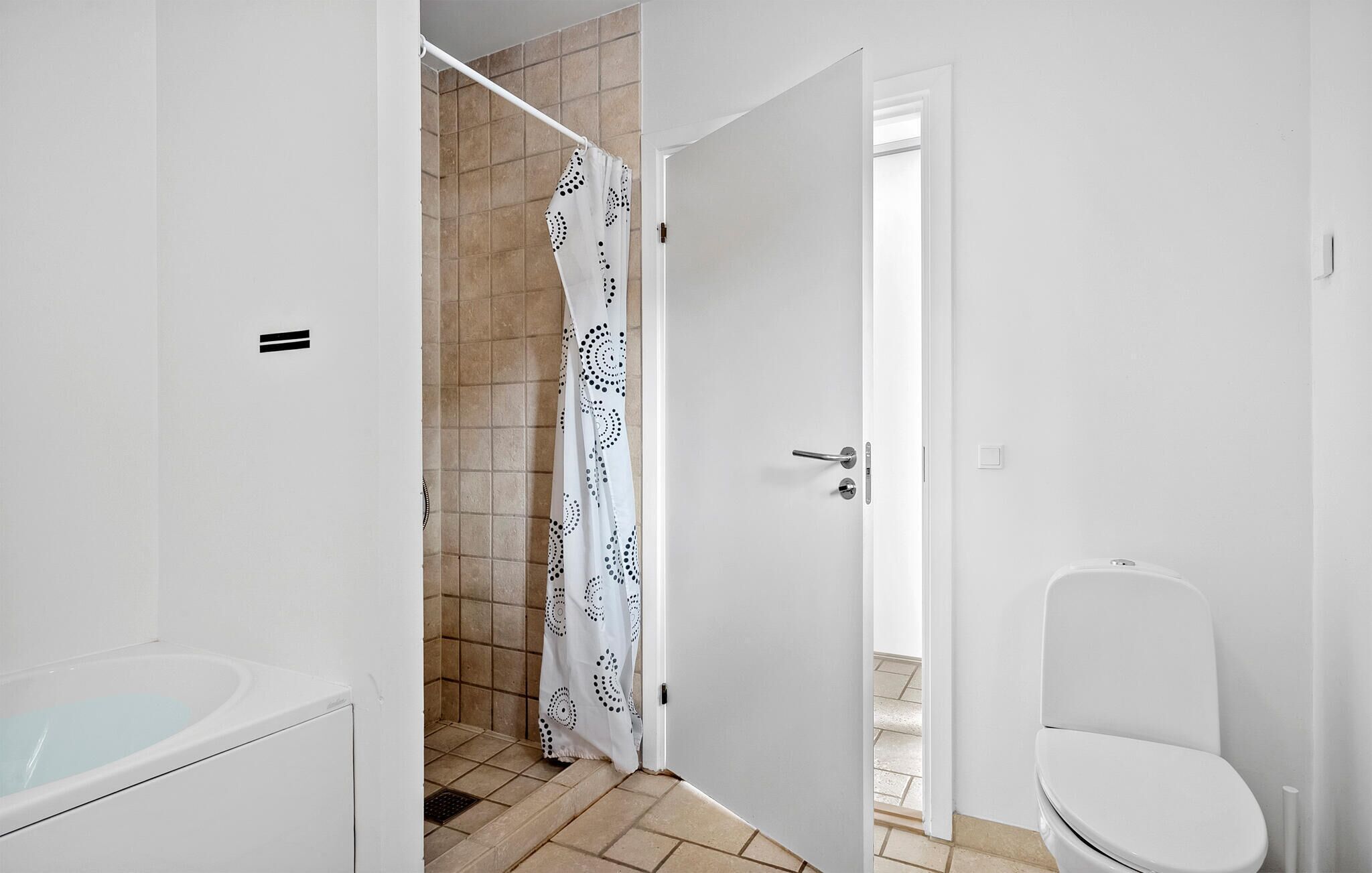 Un baño con bañera, inodoro y zona de ducha.