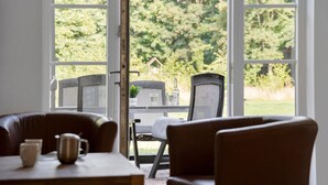 An indoor seating area with a table and chairs, a window with a view of a garden. - Amazing apartment in Nimtofte with WiFi (Nimtofte)