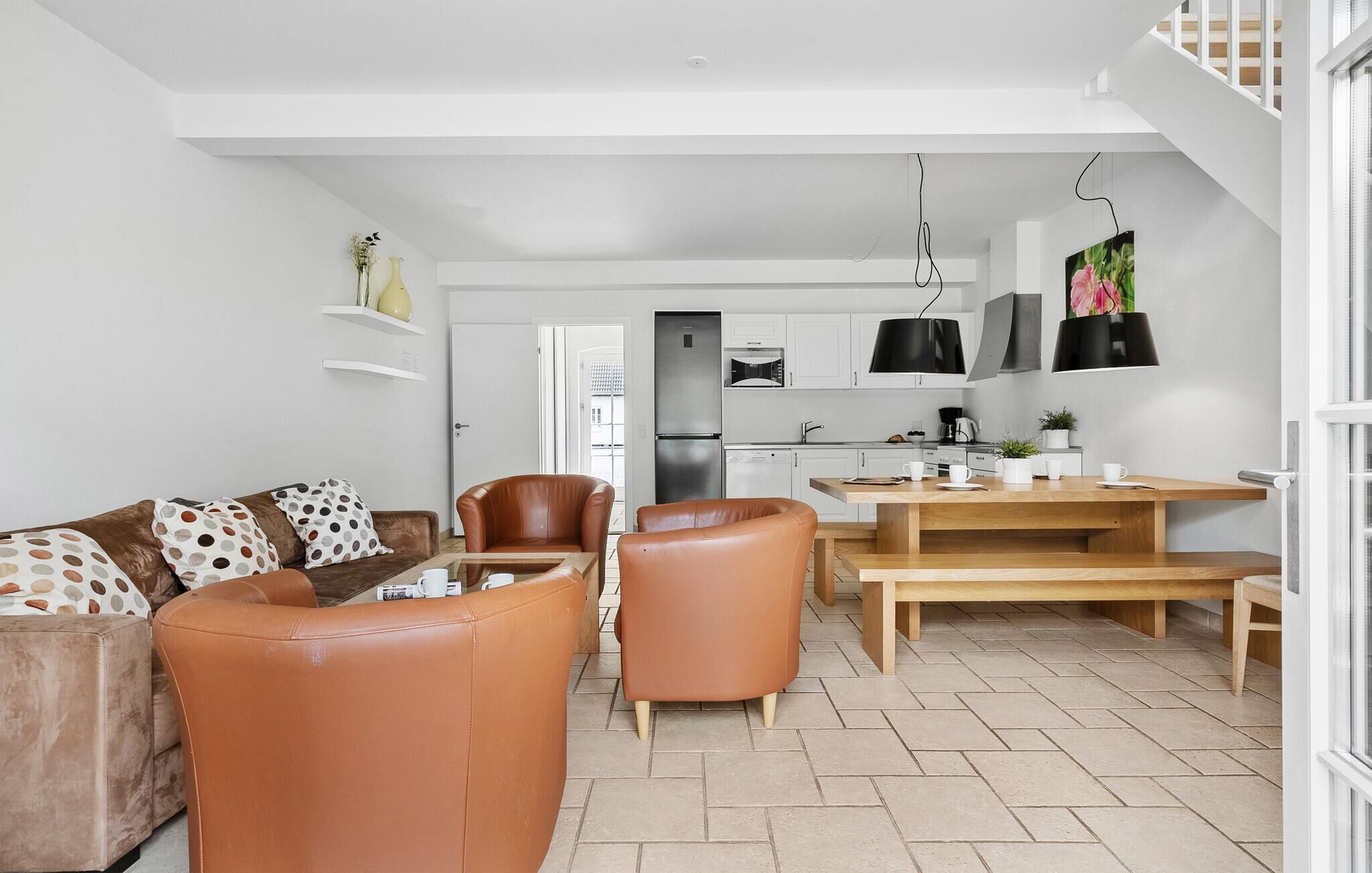 A modern apartment with a living room, dining area, and kitchen.
