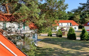 A two-story building with a red roof, surrounded by trees and a grassy area. - Amazing apartment in Altenkirchen with WiFi (Altenkirchen)
