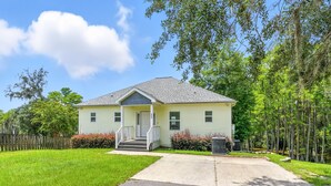A single-story house with a front porch, a small front yard, and a driveway leading to the entrance. - Compass Lake - Cypress Sunsets! (Alford)